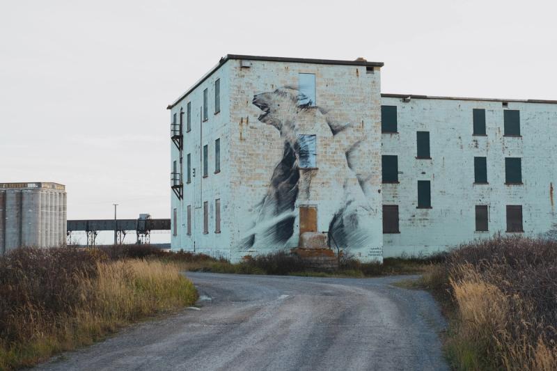 A polar bear mural on a building near the Port of Churchill in Churchill, Manitoba on September 25, 2026. The port, which was built in 1928 to ship grain from the Canadian prairies to Europe, is the only port in Northern Canada with a rail line to the south. The Arctic Gateway group hopes the port will be a way for other commodities, like oil and gas, to reach Europe.