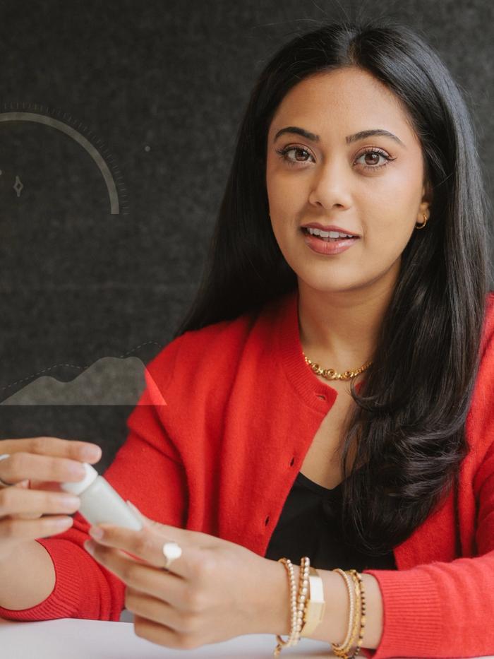 A portrait of Jaiya Varshney, the co-founder and chief operating officer of Tydra Labs, holding a vial of the company's fibrillated chitin