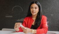 A portrait of Jaiya Varshney, the co-founder and chief operating officer of Tydra Labs, holding a vial of the company's fibrillated chitin