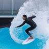 A man riding a wave on a surfboard.