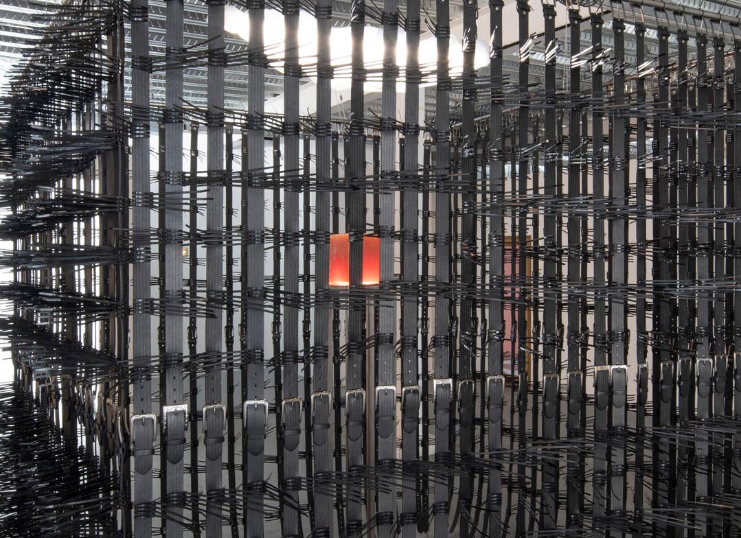 Belts and zipties forming a large cage like structure. Inside the case is a piece of turkish delight.