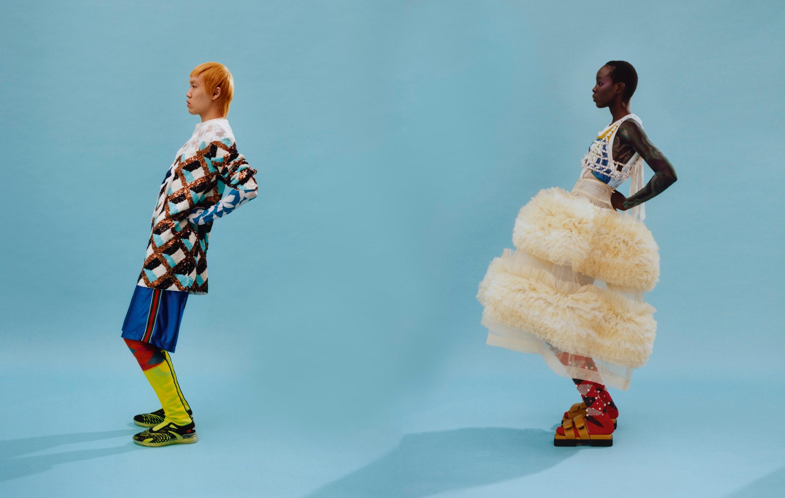 Two models stood in profile wearing colourful, patterned sportswear