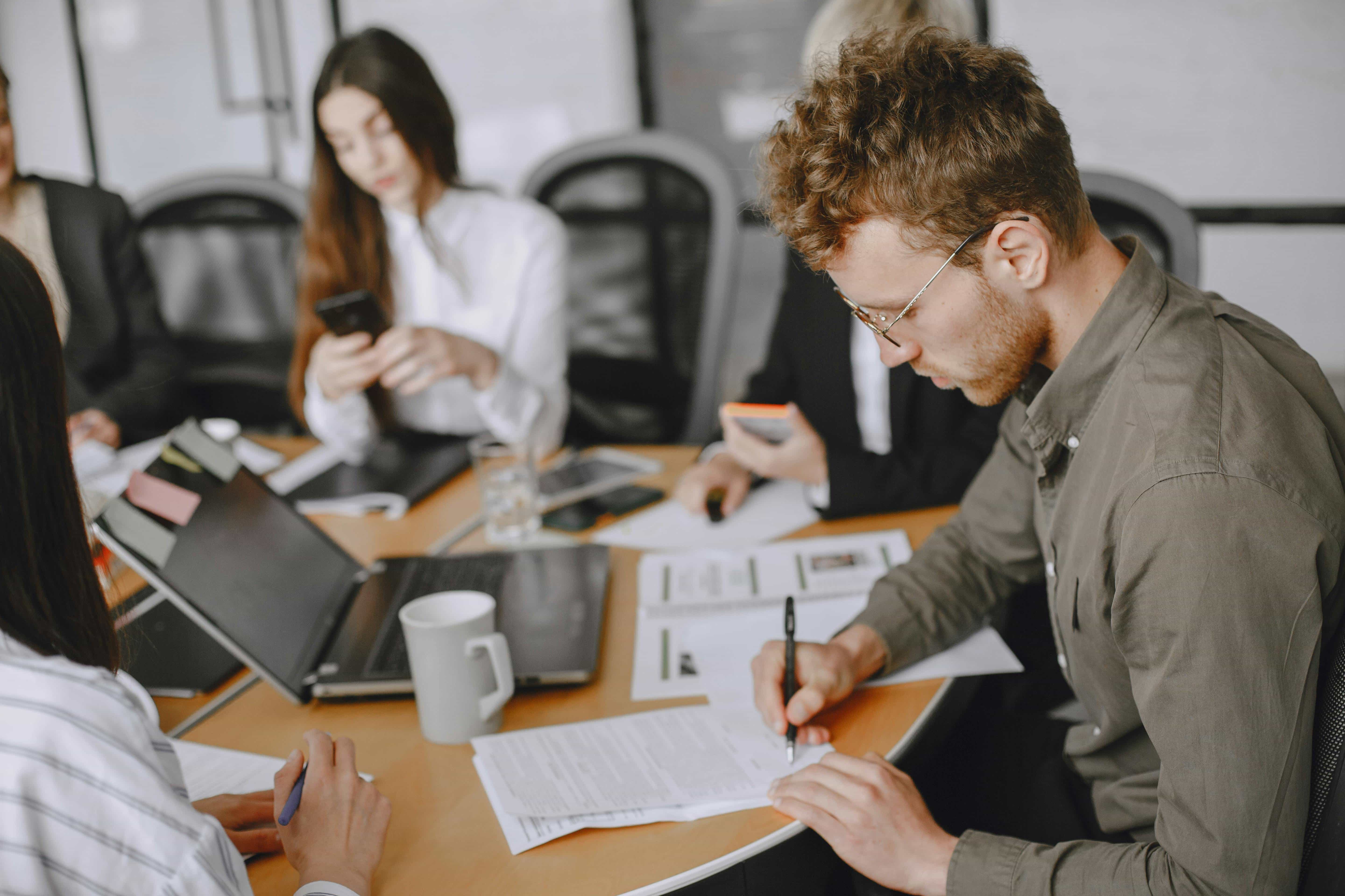 People taking notes during a meeting