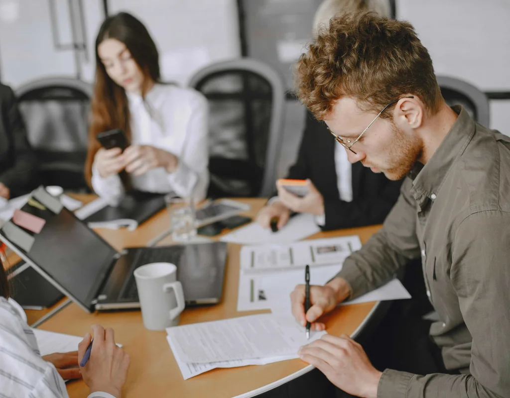 People taking notes during a meeting