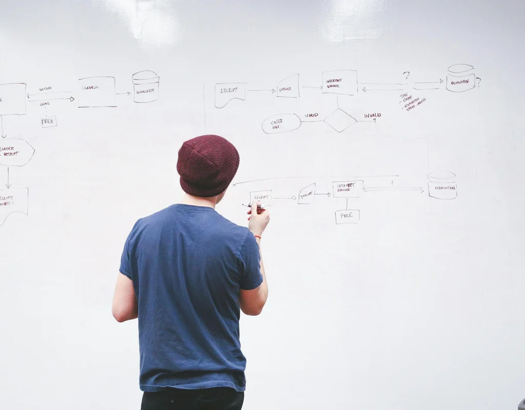 Man standing by the whiteboard planning system design