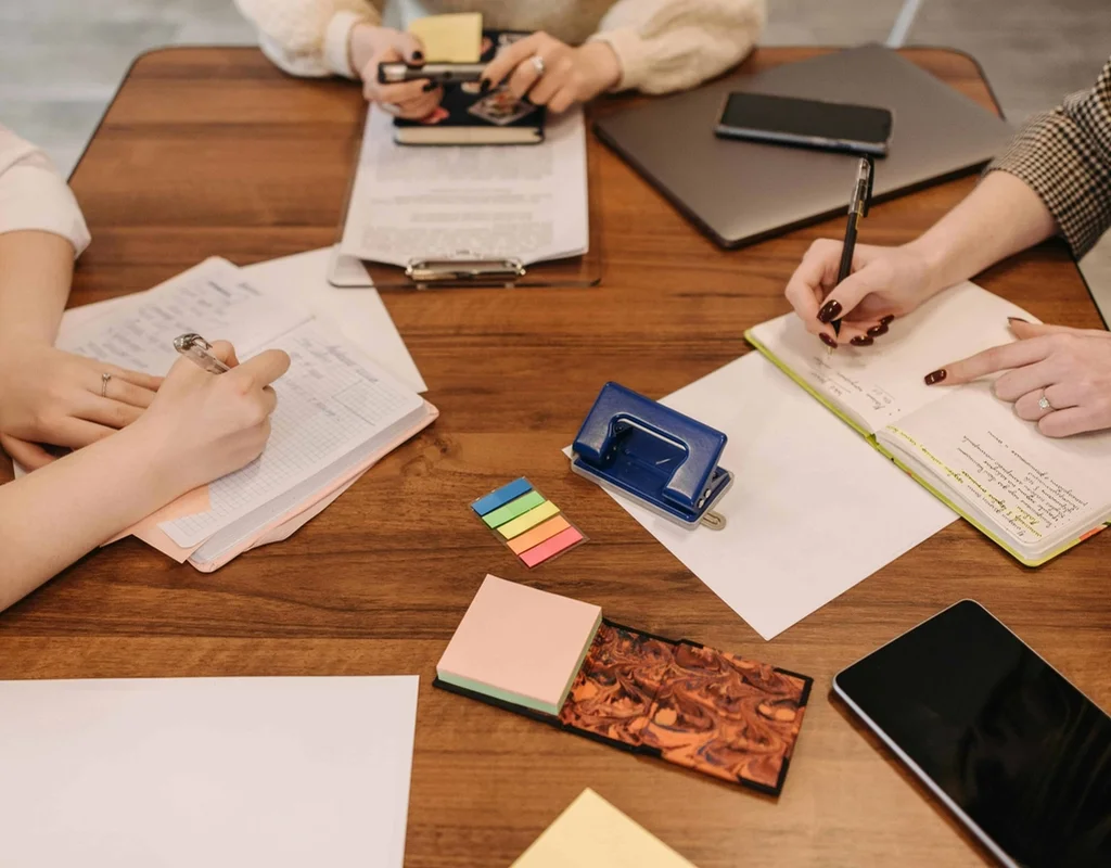 People gathered around the desk with notes