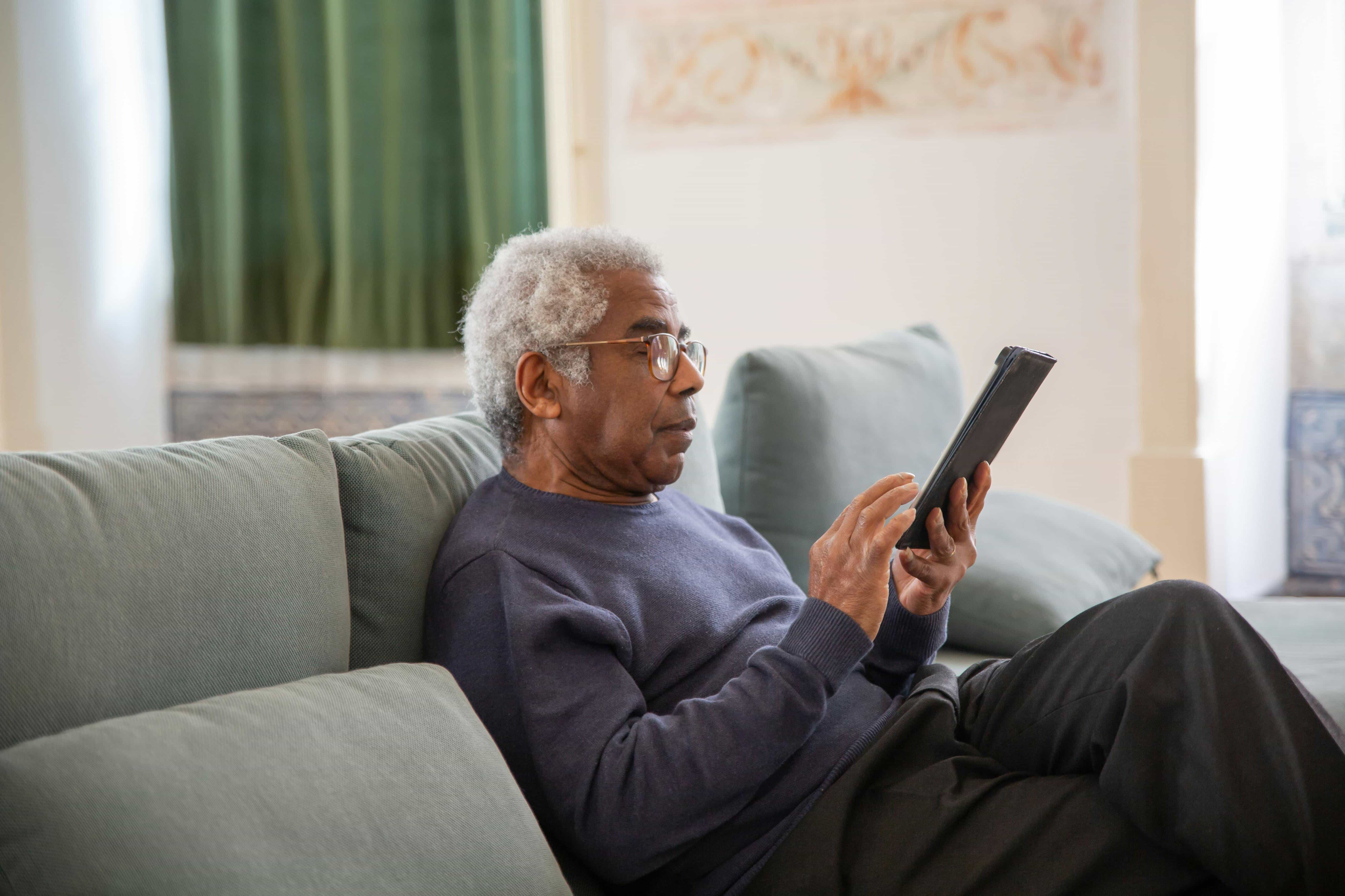 Elderly man using a tablet at home