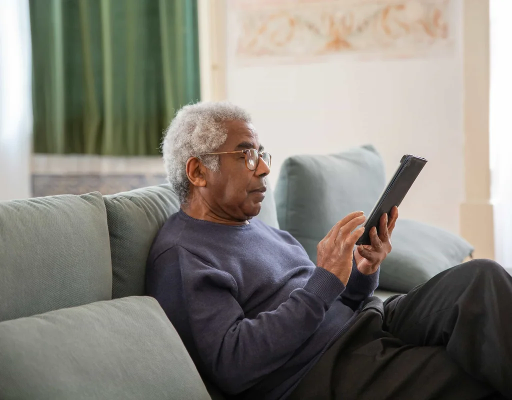 Elderly man using a tablet at home