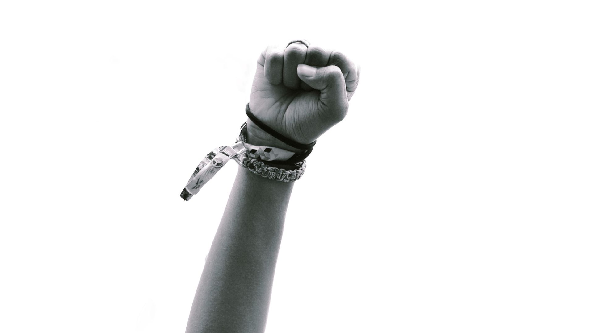 Black and white image of a fist raised in the air in protest.