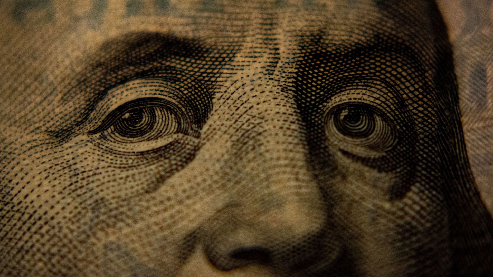 Close up of a United States one-hundred-dollar bill showing Benjamin Franklin's face. 