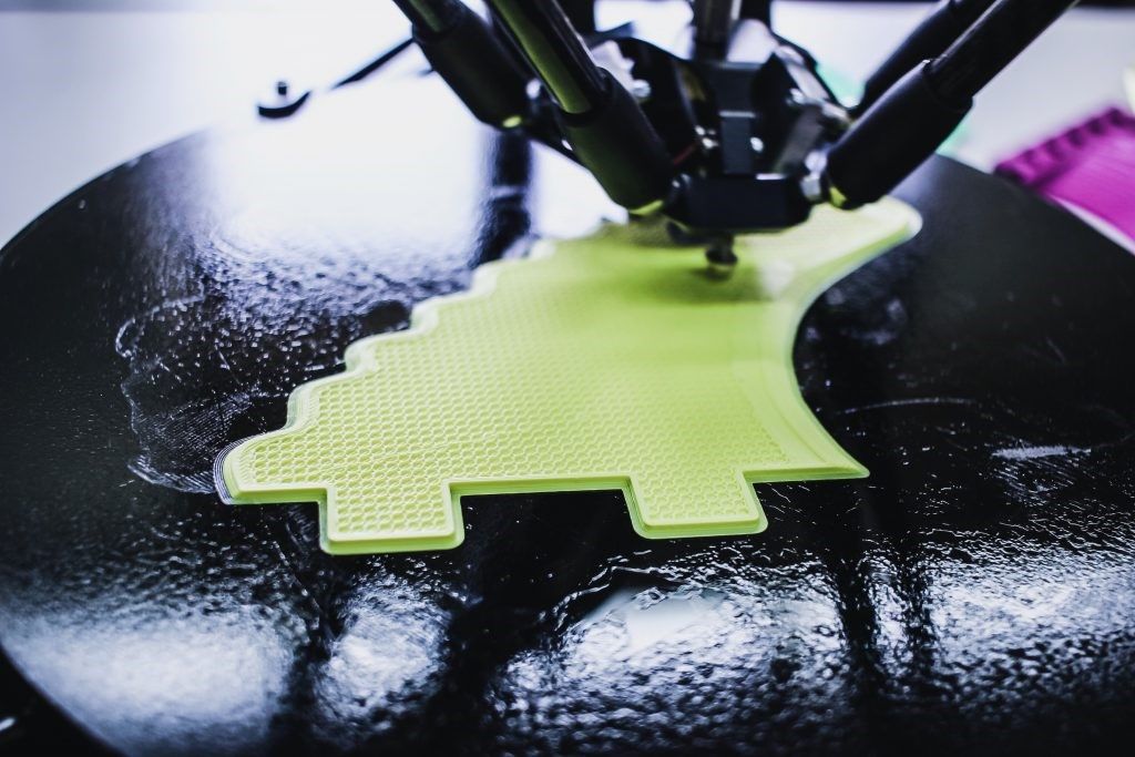 A 3D printer creating the first layer of resin for a green object. 
