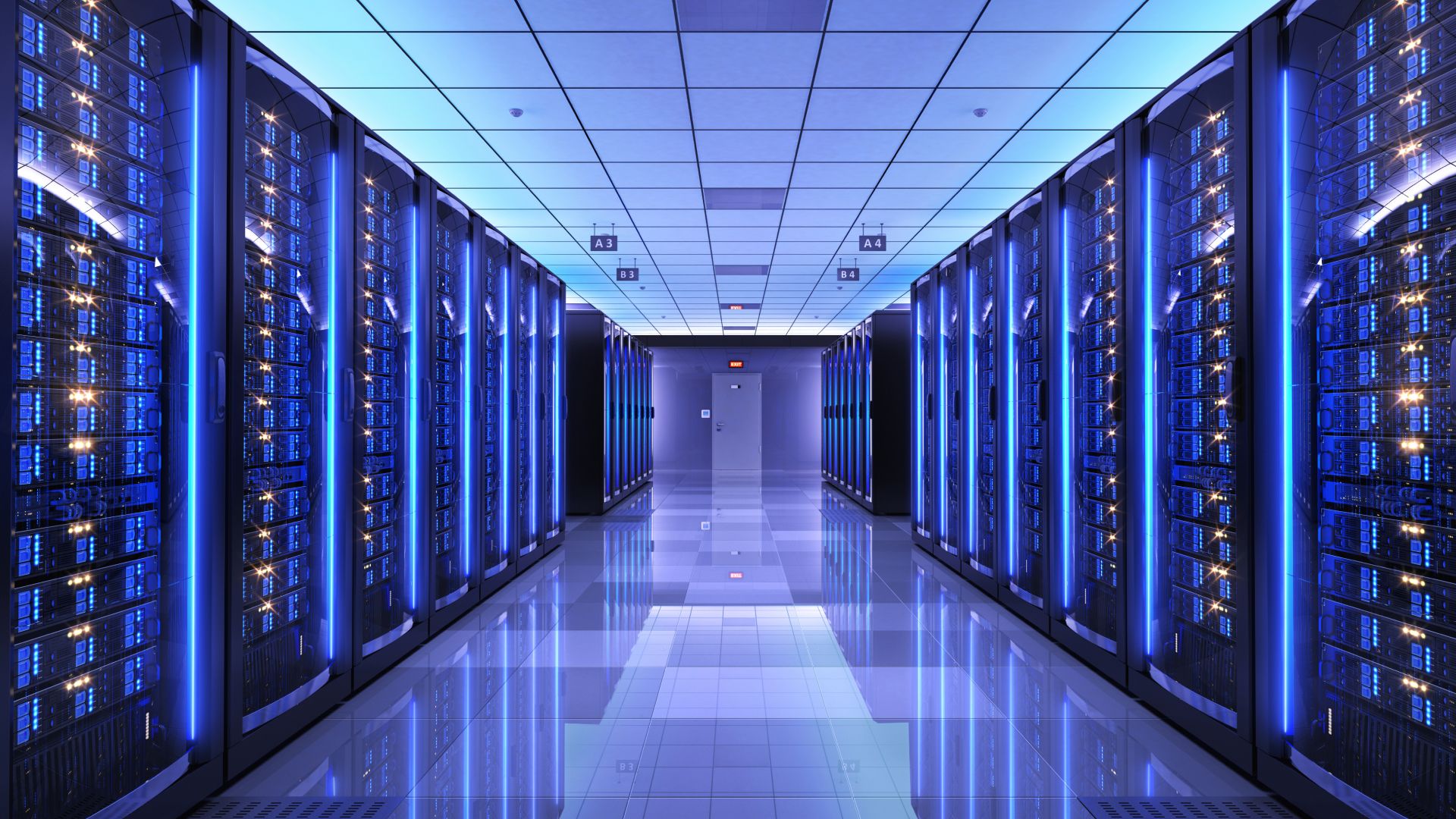 Blue lit hallways with rows of servers from the floor to the ceiling on each side . 