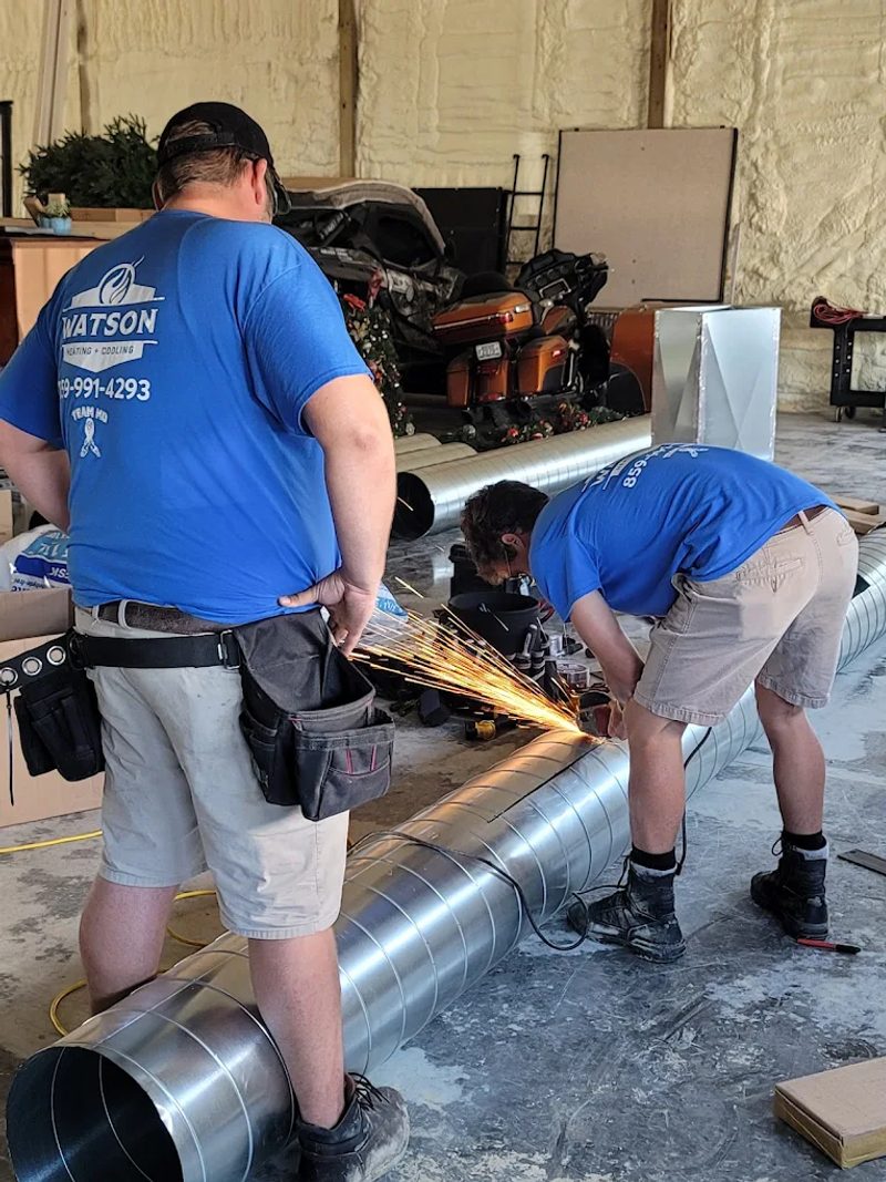 Mike Watson and son Josh fabricating ductwork together in branded shirts