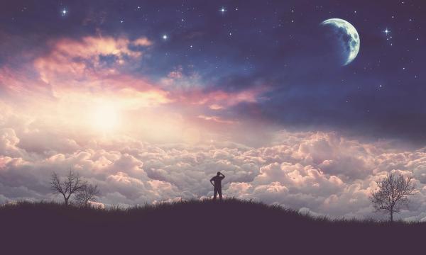 man looking into the sky seeing clouds, stars, and a moon