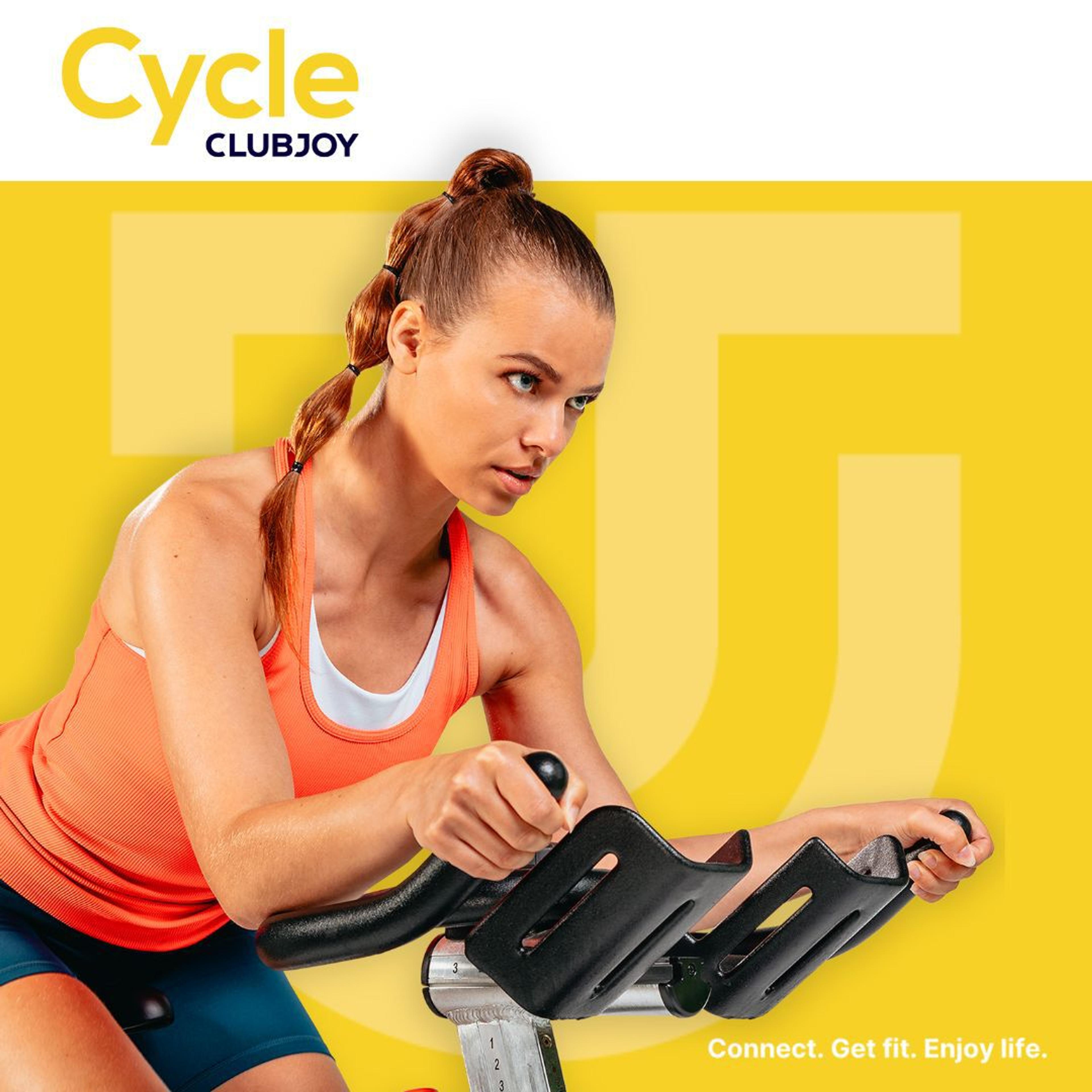 Een vrouw doet een intense spinning workout op een fiets, gebruikt voor een Clubjoy Cycle promotie.