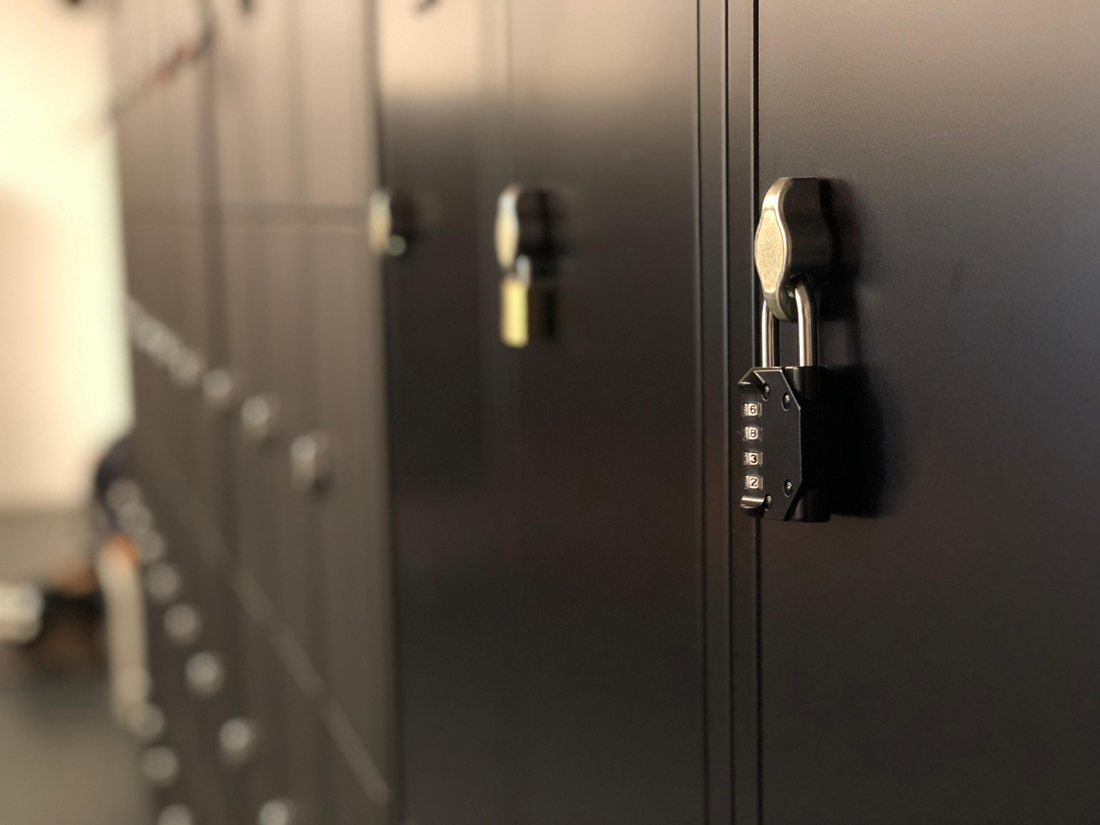 Een close-up van zwarte lockers met cijfersloten in een kleedkamer.