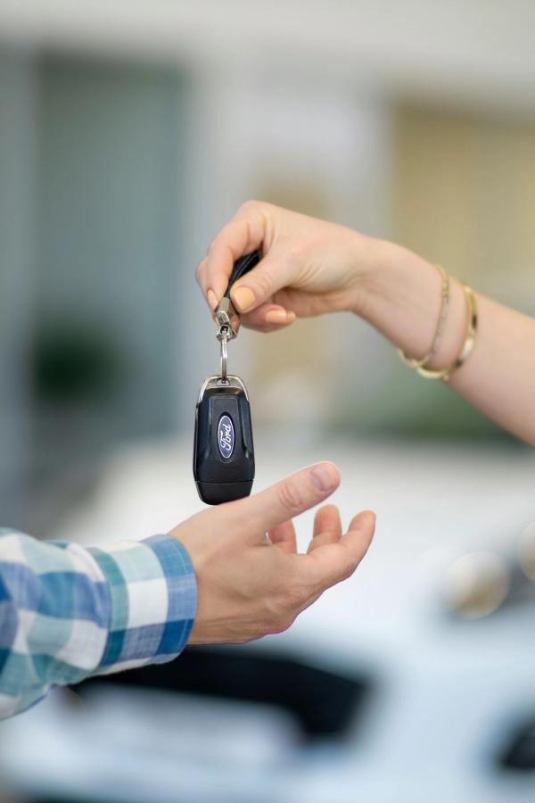 a car key is being given to an owner