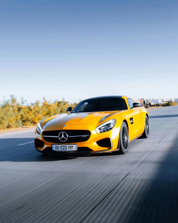 Yellow sporty Mercedes driving on the road