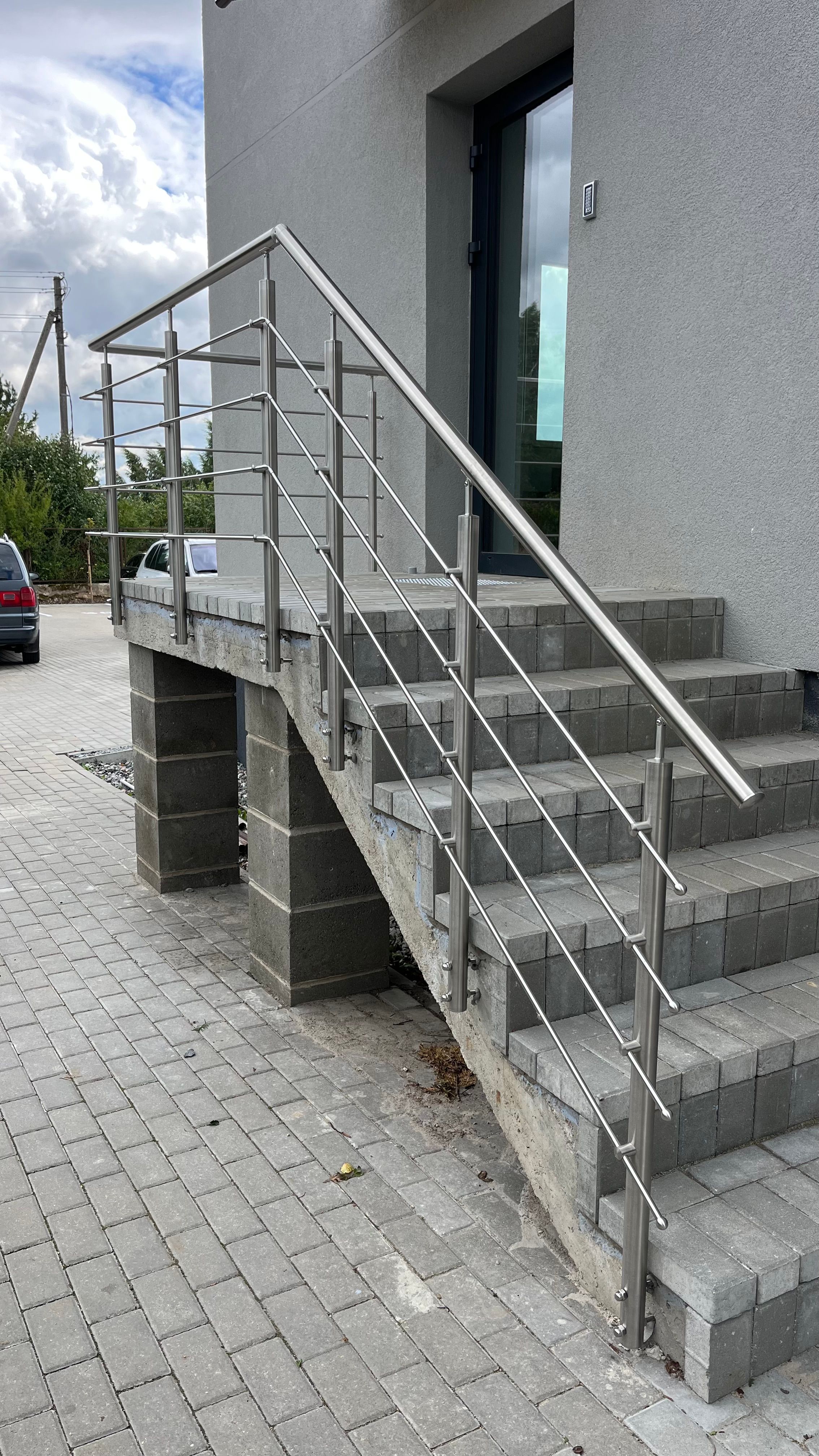 Nerūdijančio plieno turėklai, sumontuoti prie namo įėjimo