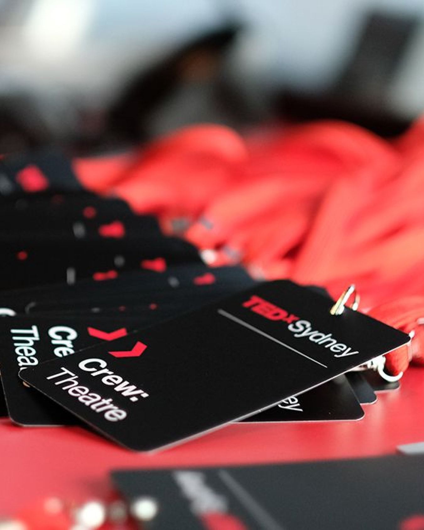Close up of a pile of black crew passes on red lanyards for the event.