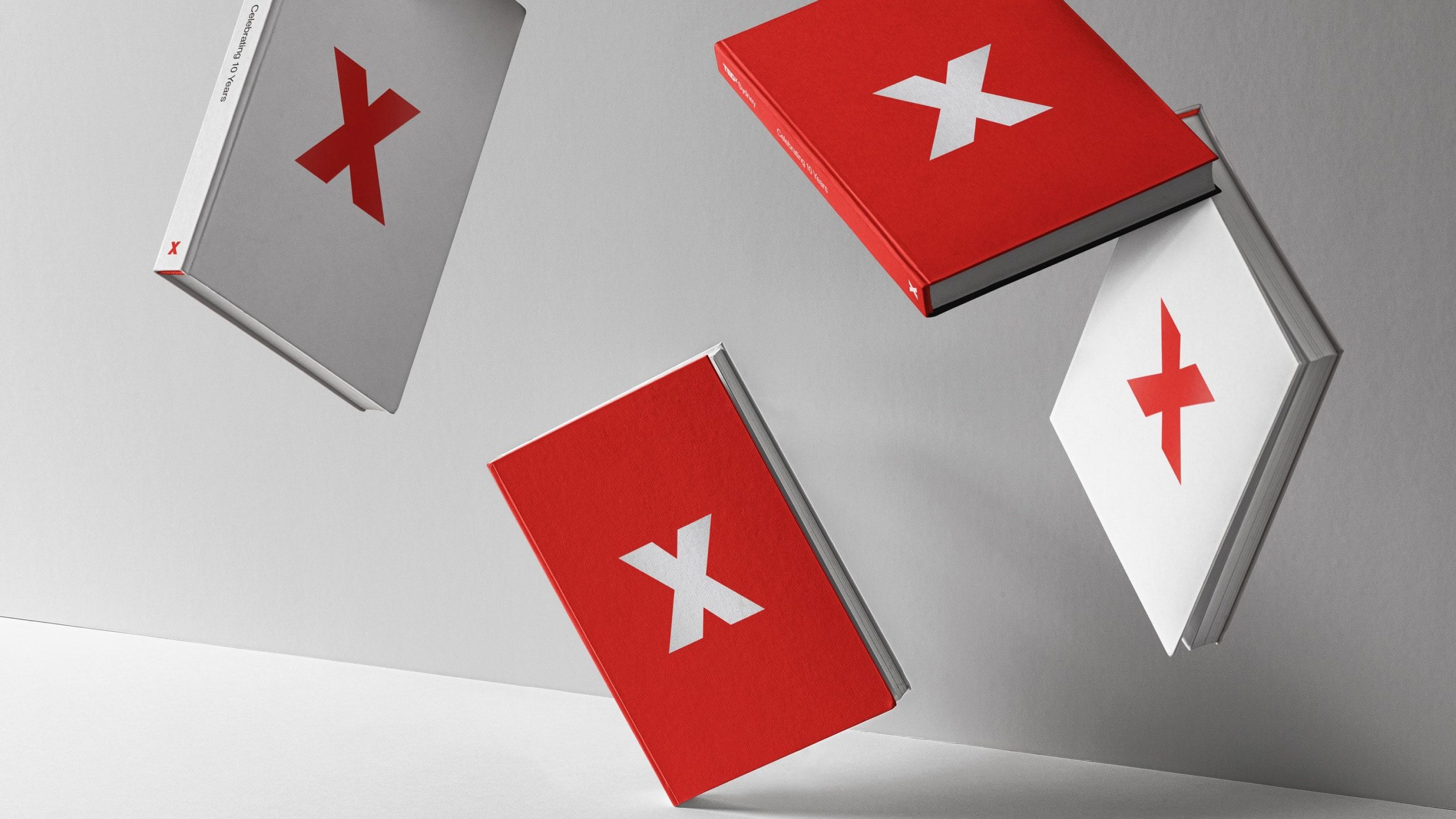 An array of red and white hardcover books with the logomark as the cover design.