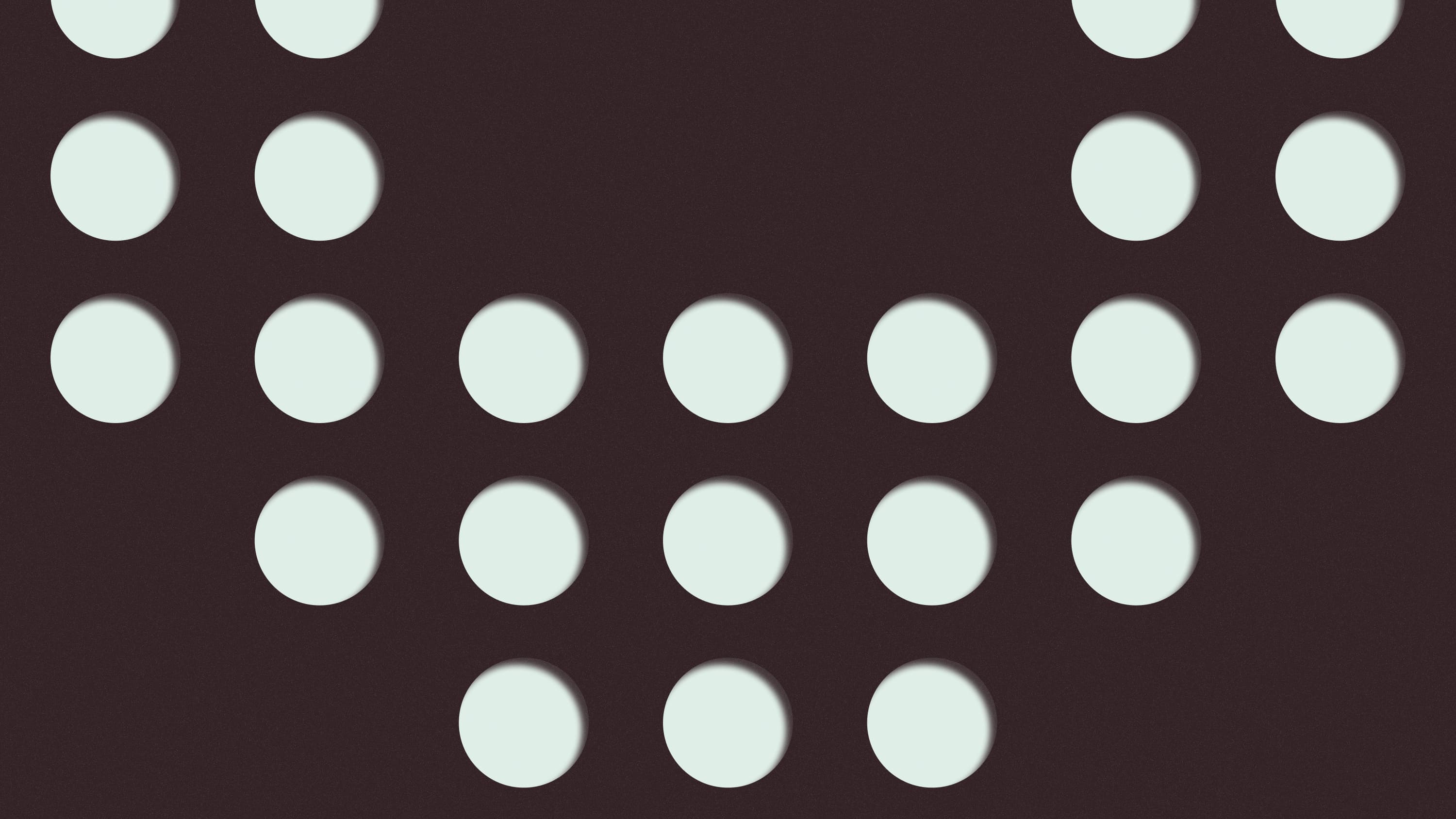 Mint circular cutouts in staggered rows on dark brown.