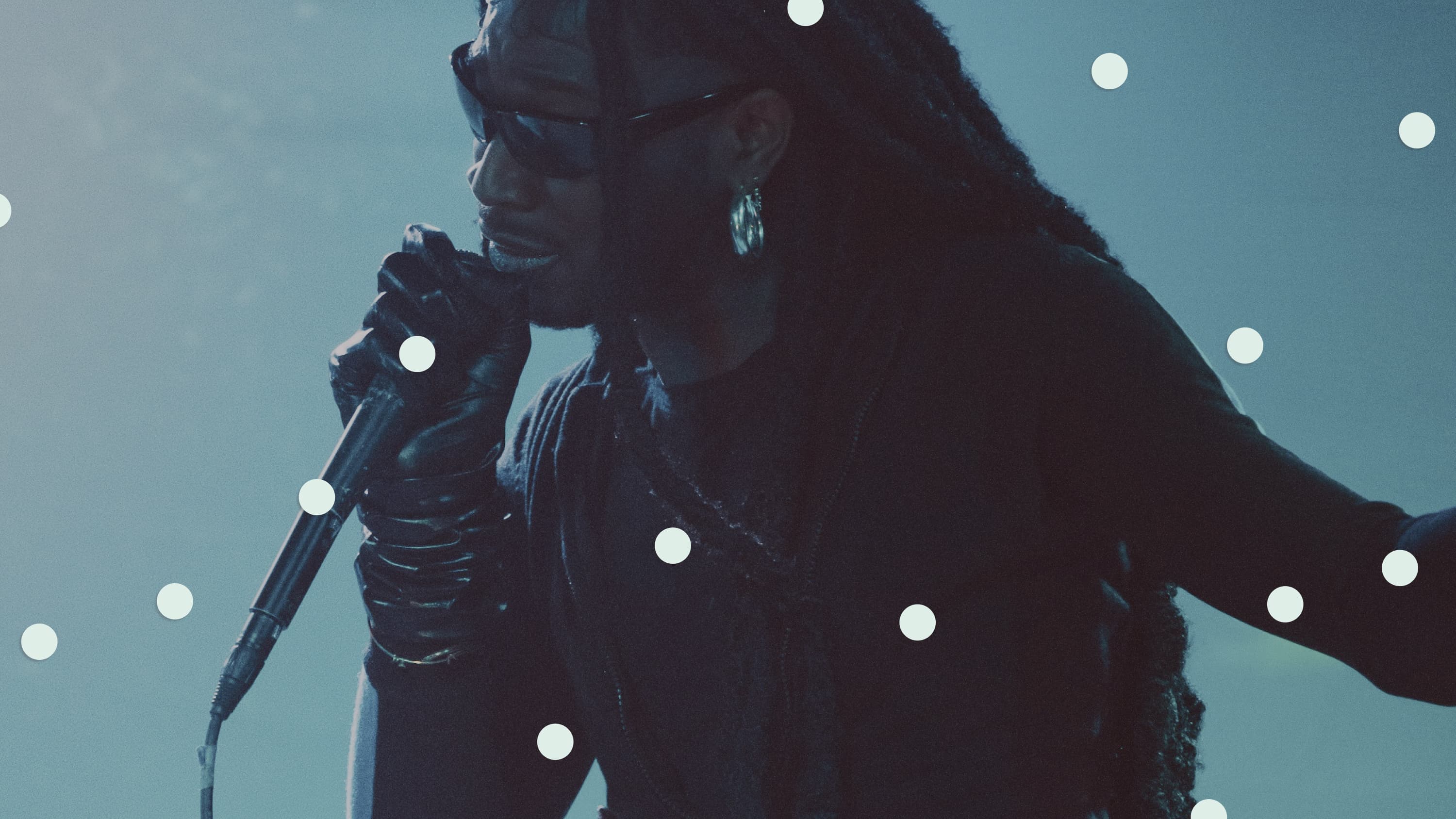 Singer performing under blue lighting, overlaid with mint circles.