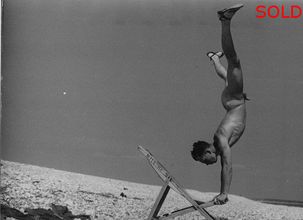 Young man doing a handstand on deckchair [P49]