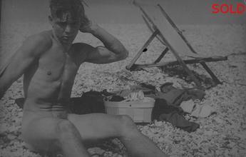 Len seated on beach beside deck chair [P38]