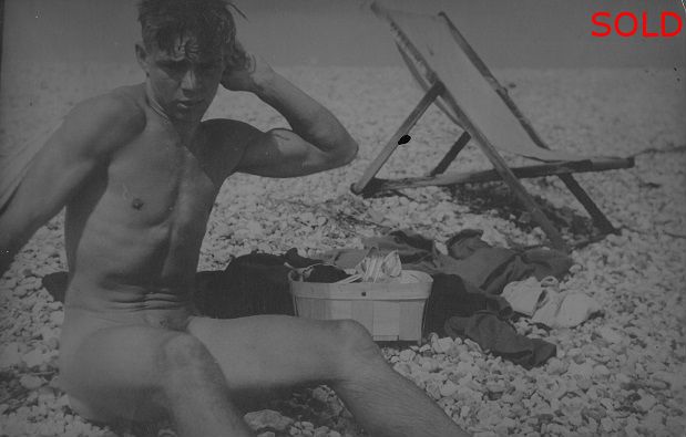 Len seated on beach beside deck chair [P38]