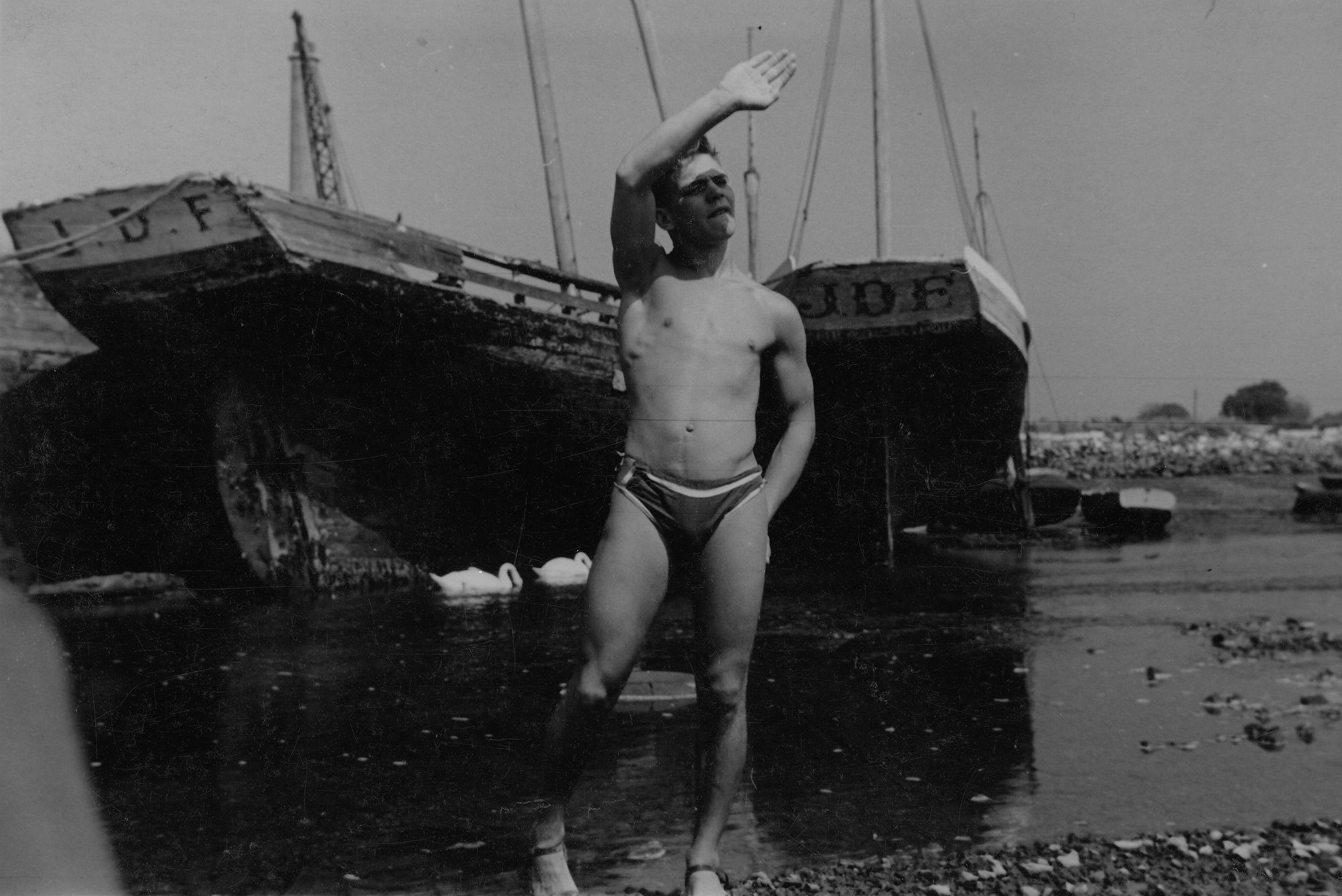 Young man at water’s edge with raised arm [P12]