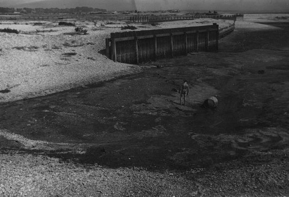 Distant male figure walking across estuary [P73]