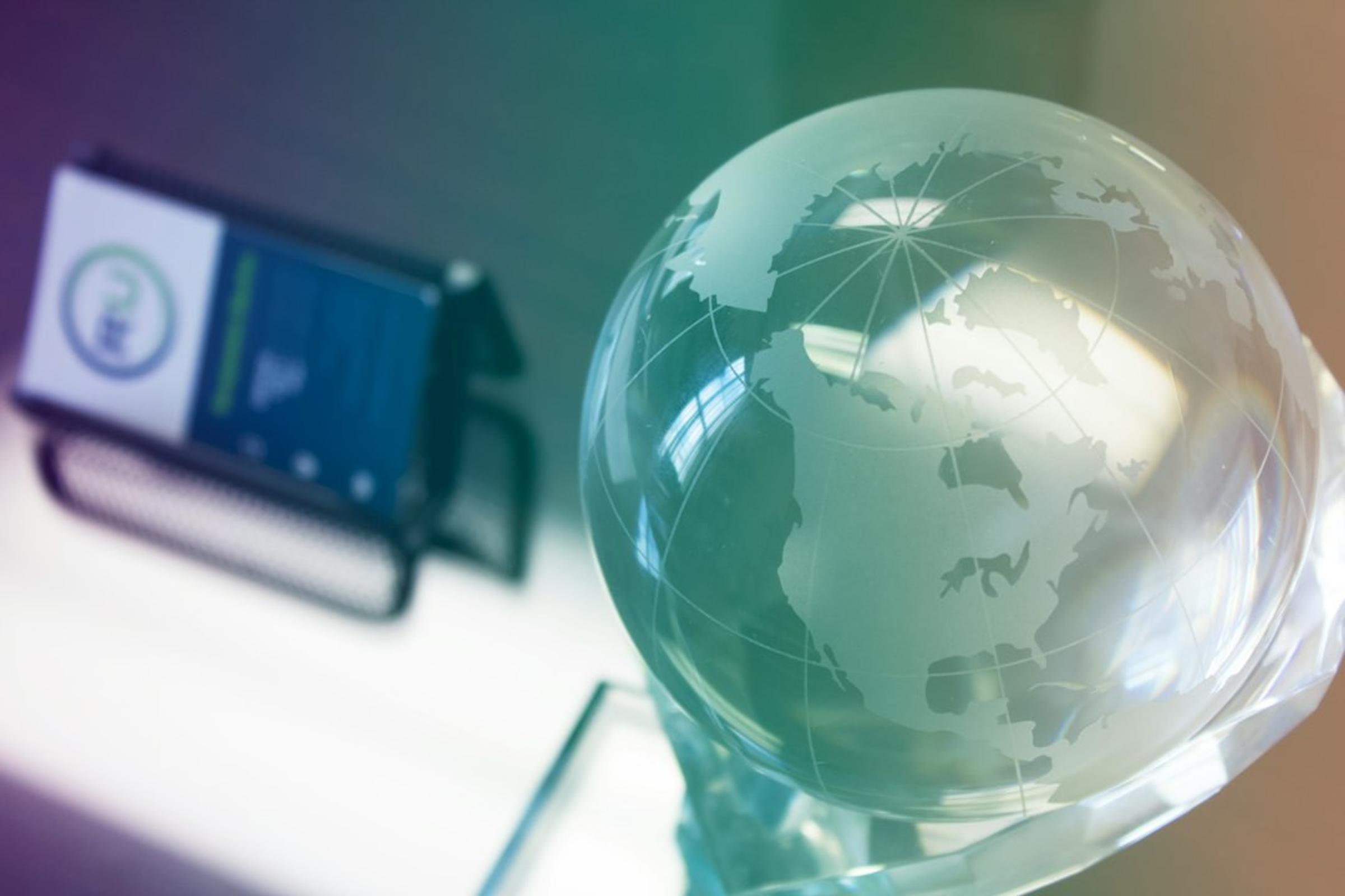 Glass globe paperweight on a desk, with a blurred business card holder in the background