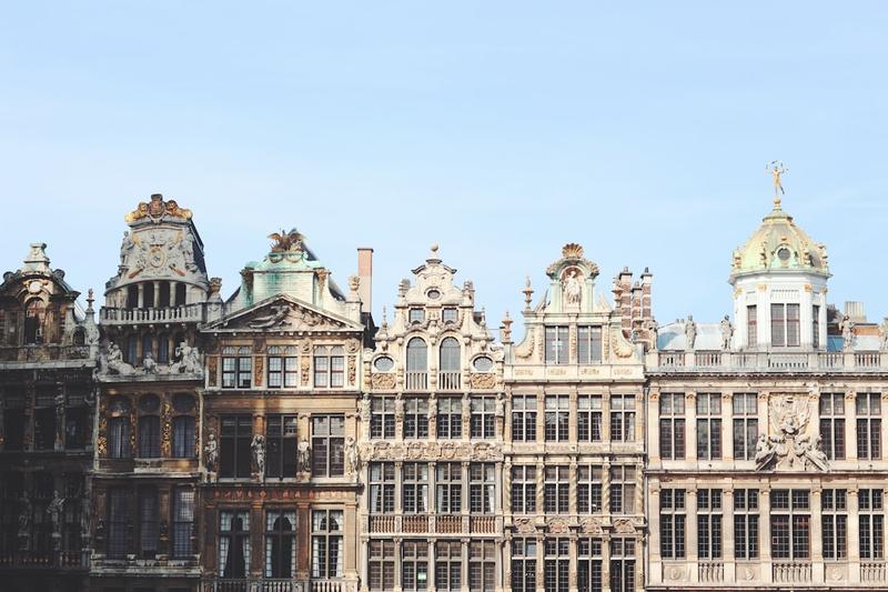 Ornate guild house facades on the Grand-Place in Brussels against a clear blue sky
