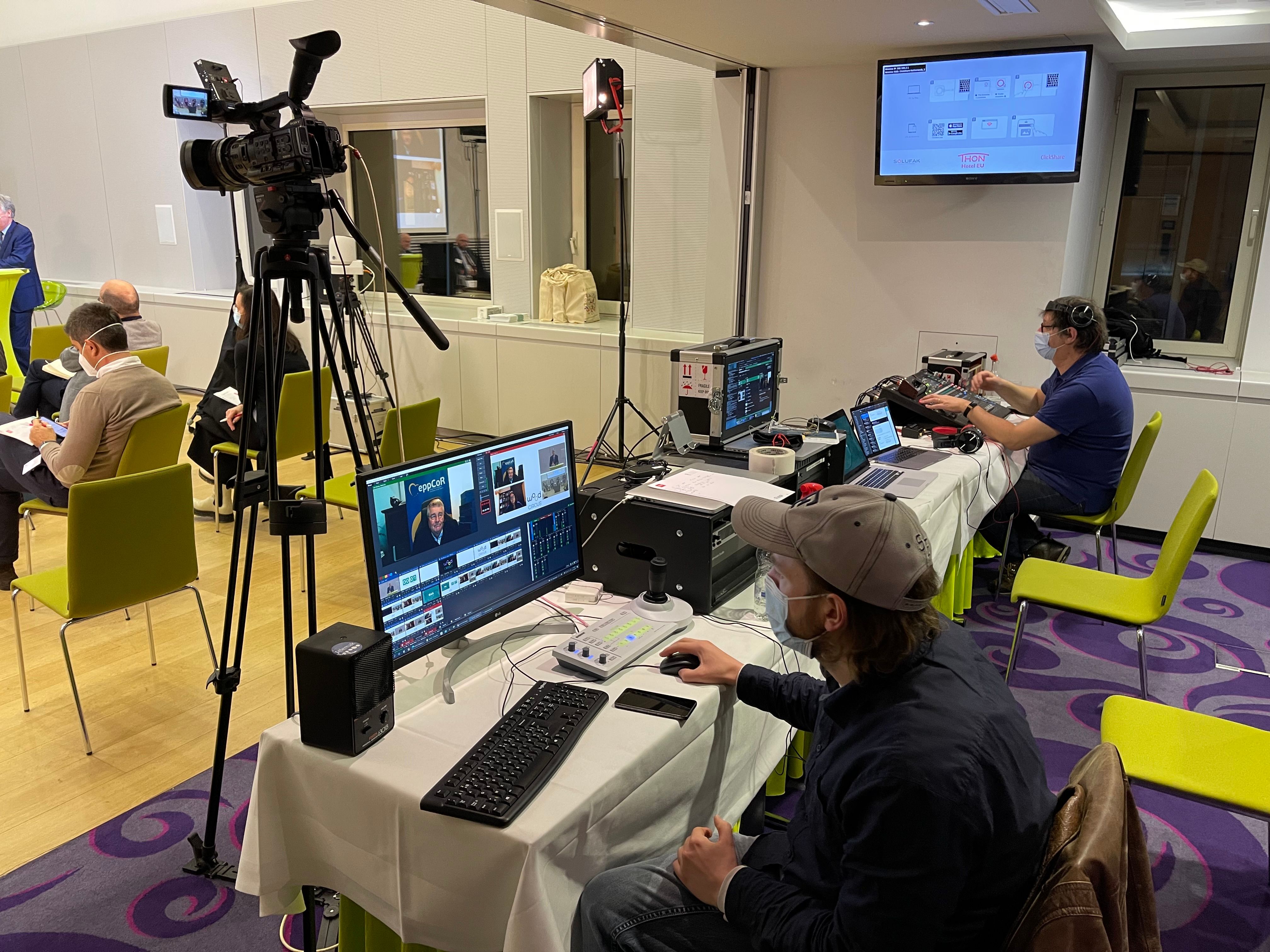 A hybrid event in progress: an audience in the room while an operator streams the session to people watching elsewhere