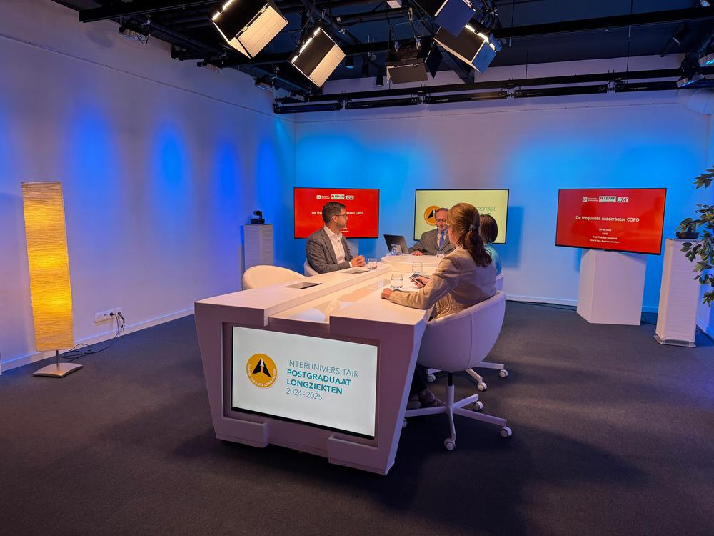 Four people at a studio desk recording a session for the Interuniversitair Postgraduaat Longziekten 2024-2025
