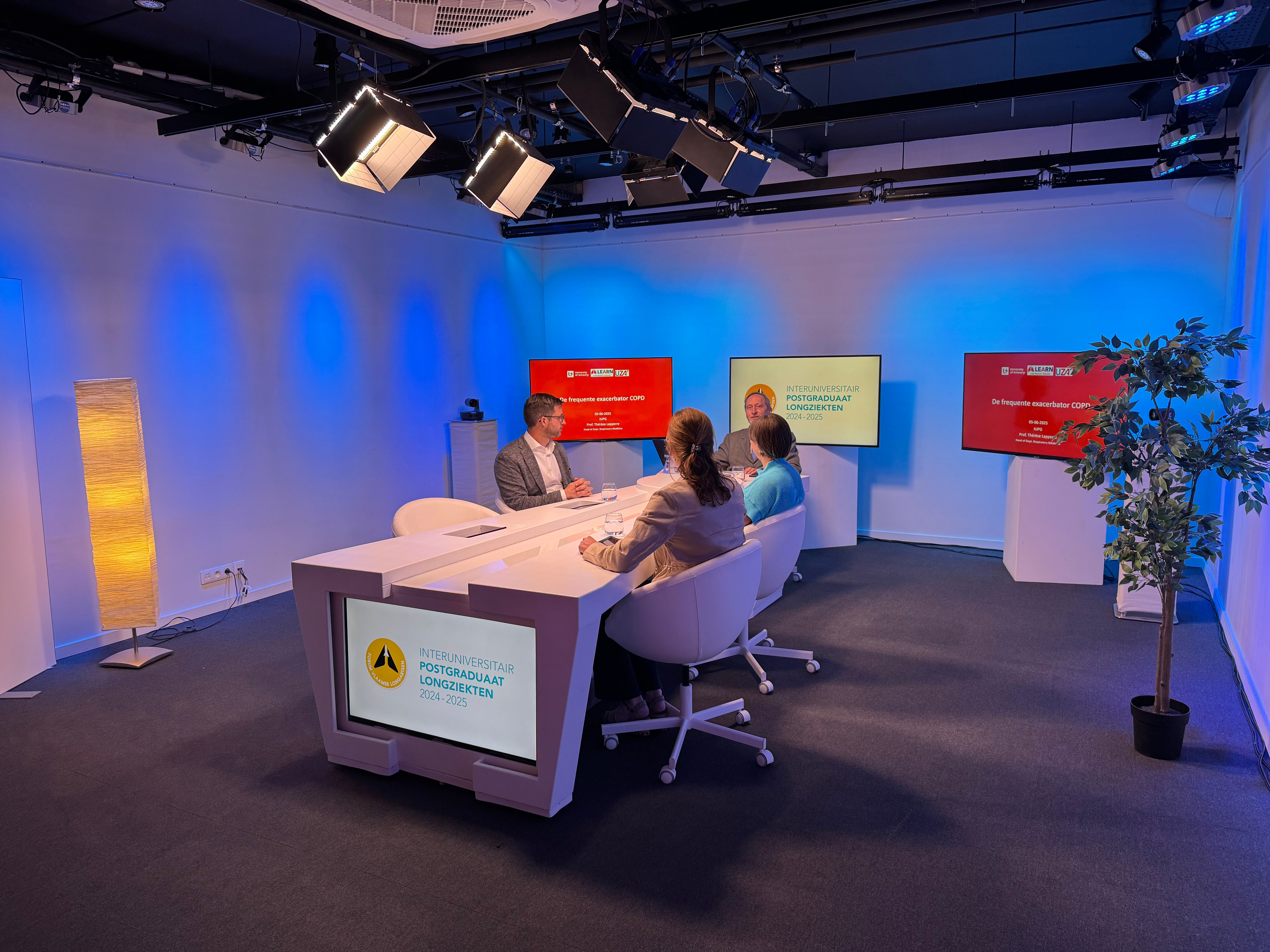 The 2 Stream studio in Zaventem, lit for a panel recording around a white desk