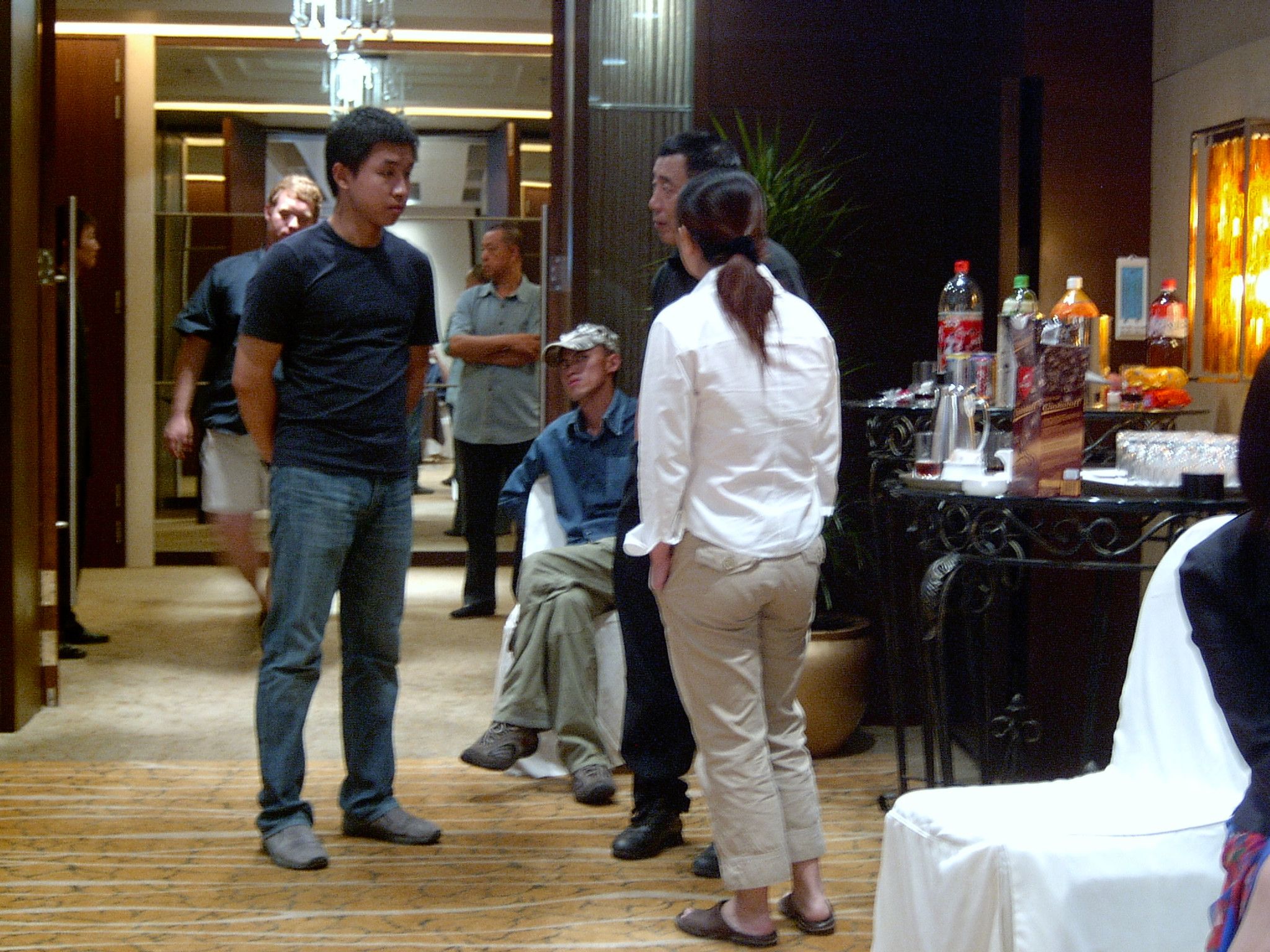 People talking in a hotel function room during a break, with a drinks table to the side