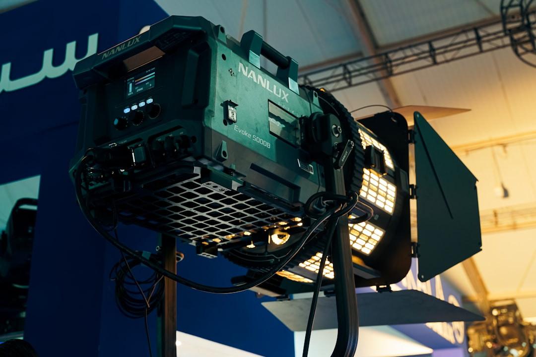 Nanlux Evoke 5000B LED spotlight with barn doors mounted on a stand beneath lighting truss at an event venue