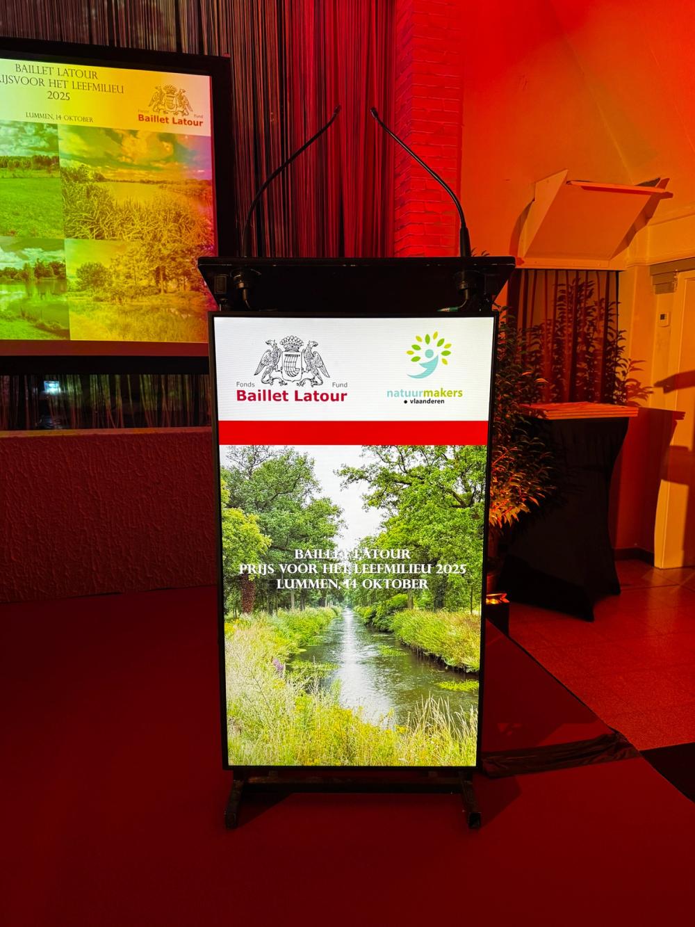 Lectern screen for the Baillet Latour Prijs voor het Leefmilieu 2025 in Lummen, with the Natuurmakers Vlaanderen logo