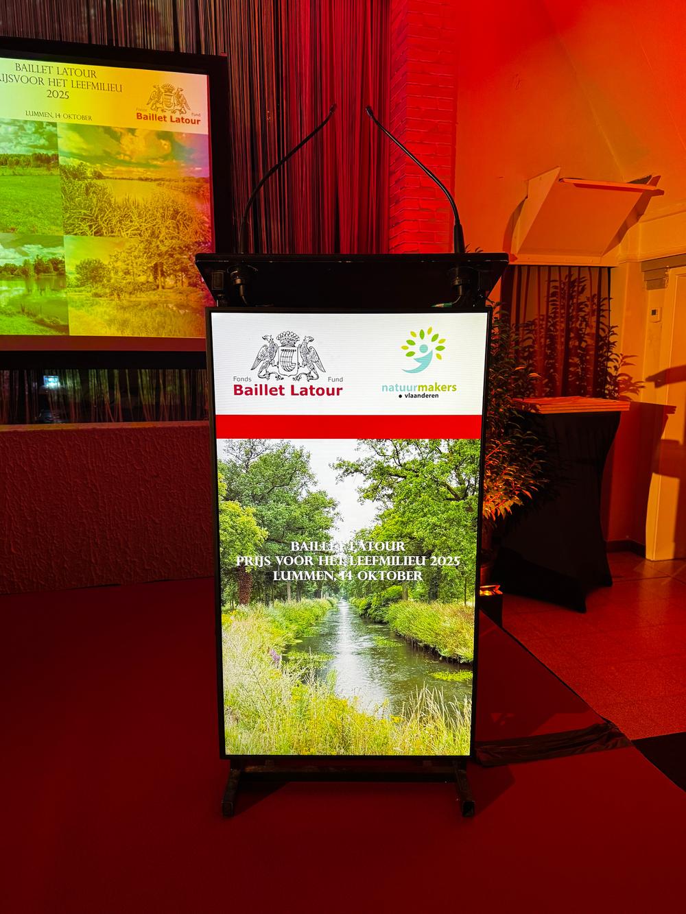 Lectern screen for the Baillet Latour Prijs voor het Leefmilieu 2025 in Lummen, with the Natuurmakers Vlaanderen logo