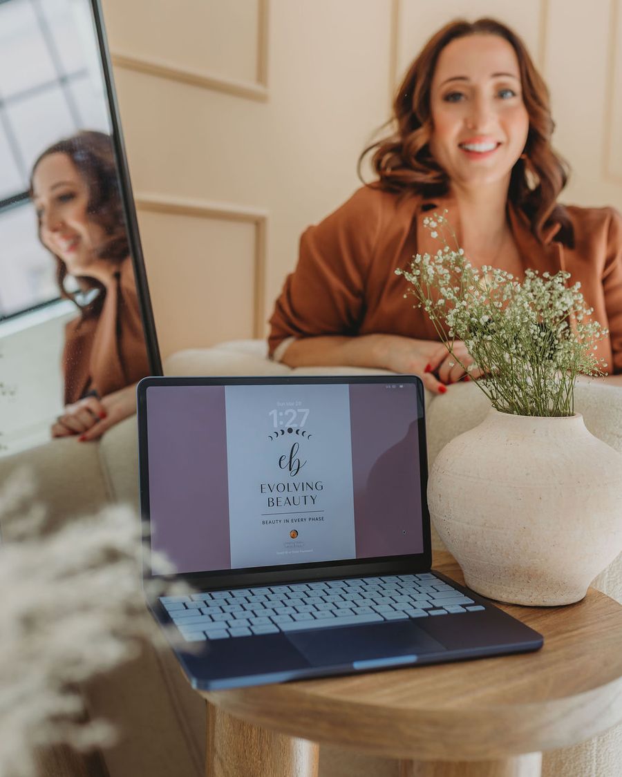 Owner sitting in calm space with laptop and mirror