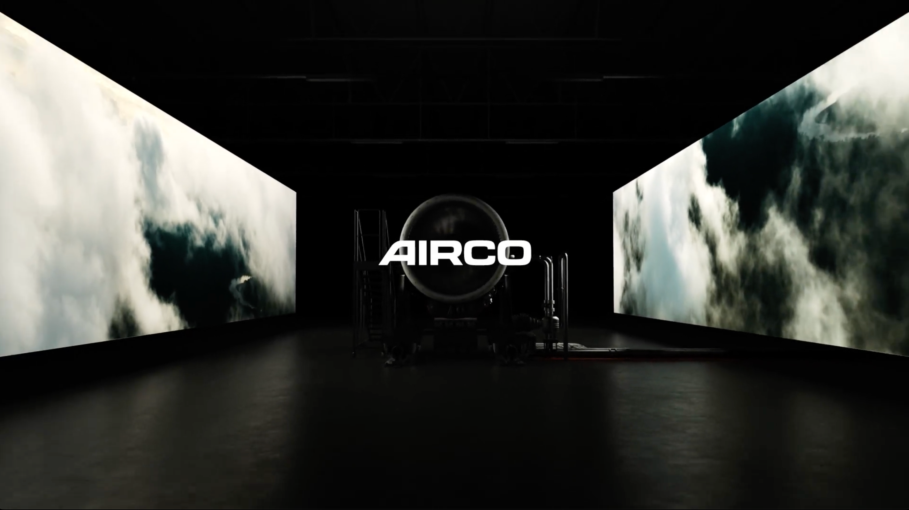 AIRCO logo in a dark room with an engine behind it.