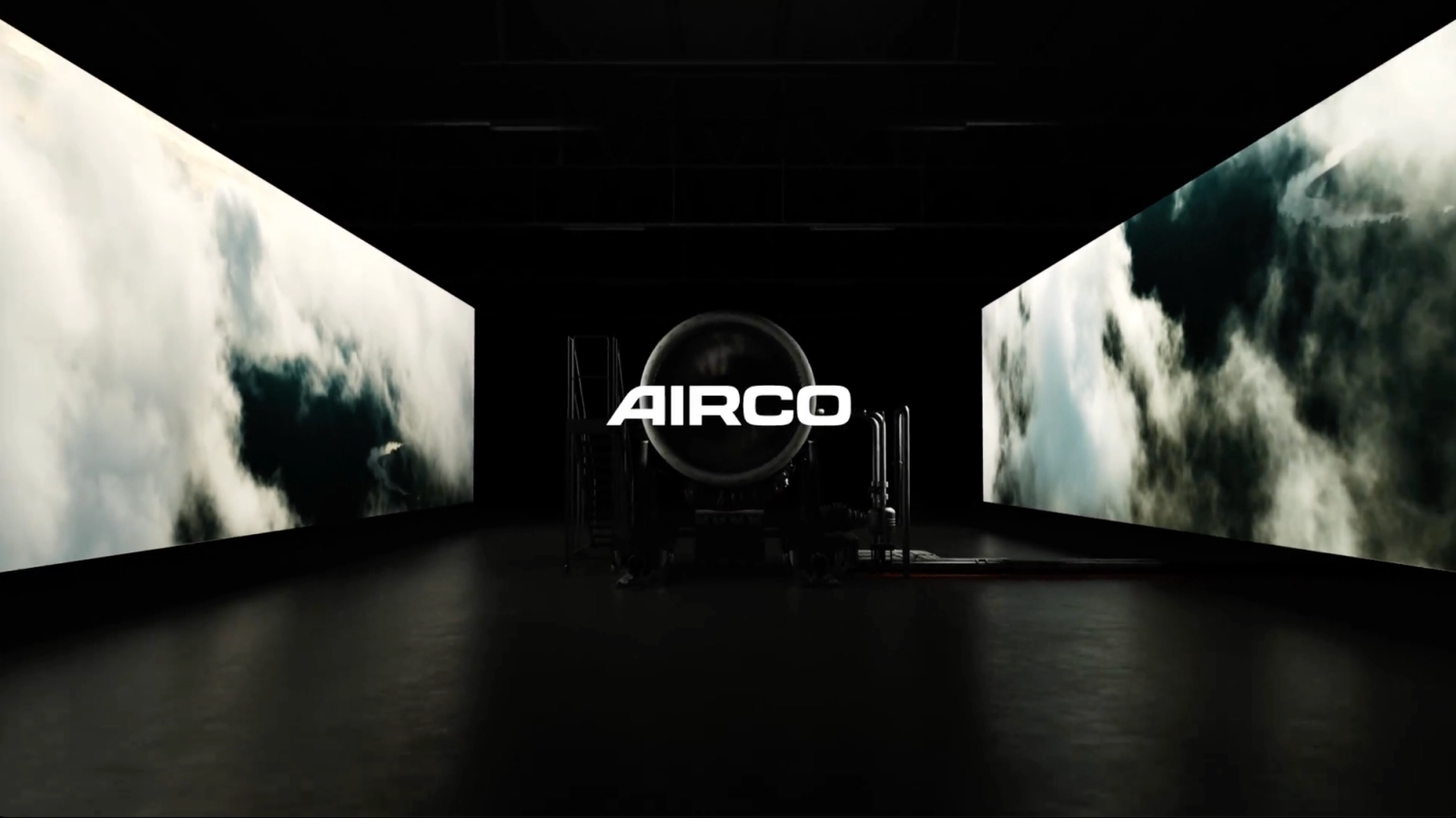 AIRCO logo in a dark room with an engine behind it.
