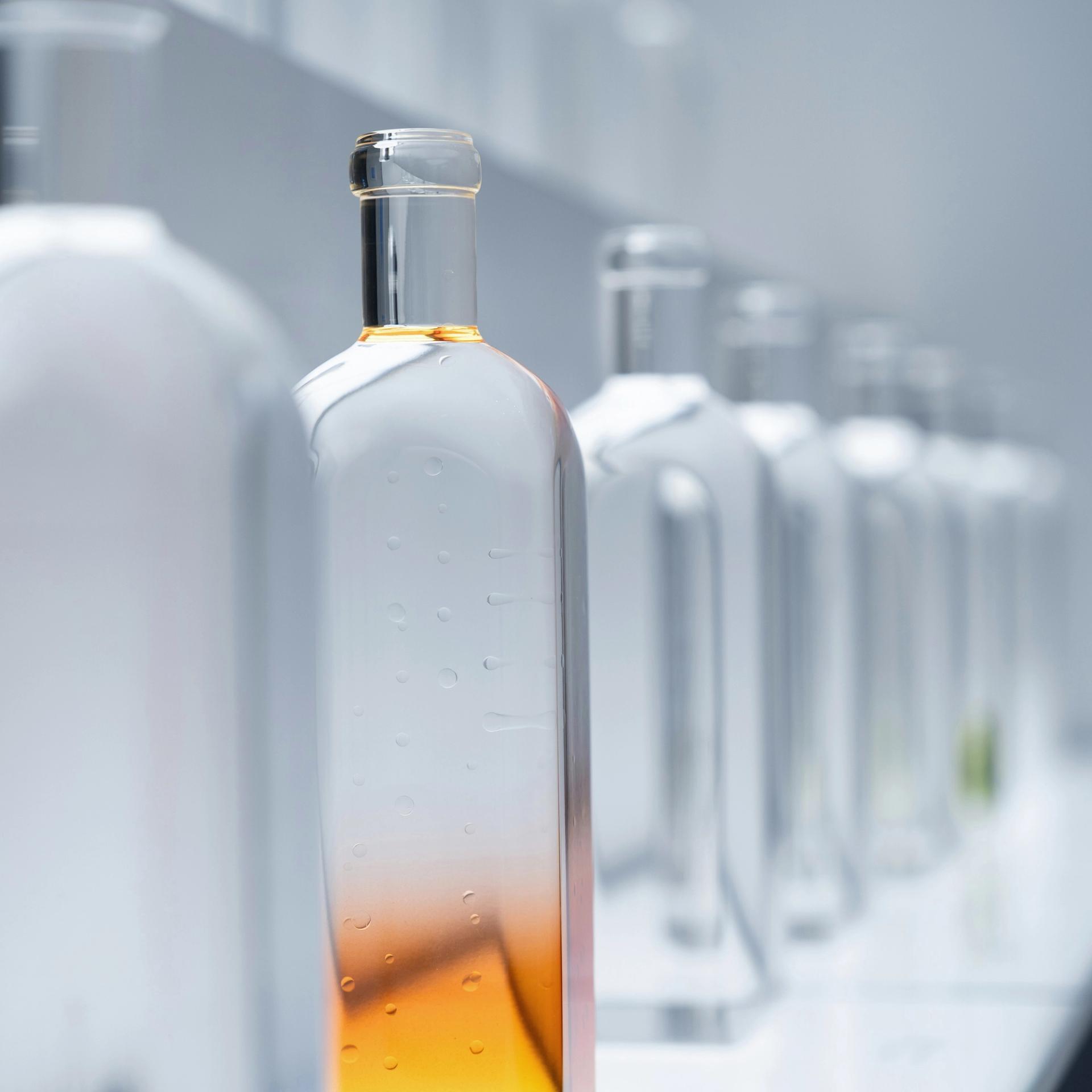 A row of clear bottles filled with Ethanol