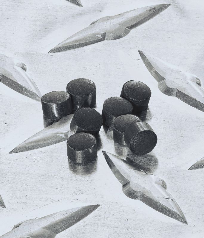 Eight catalyst pellets sitting on top of a metal table