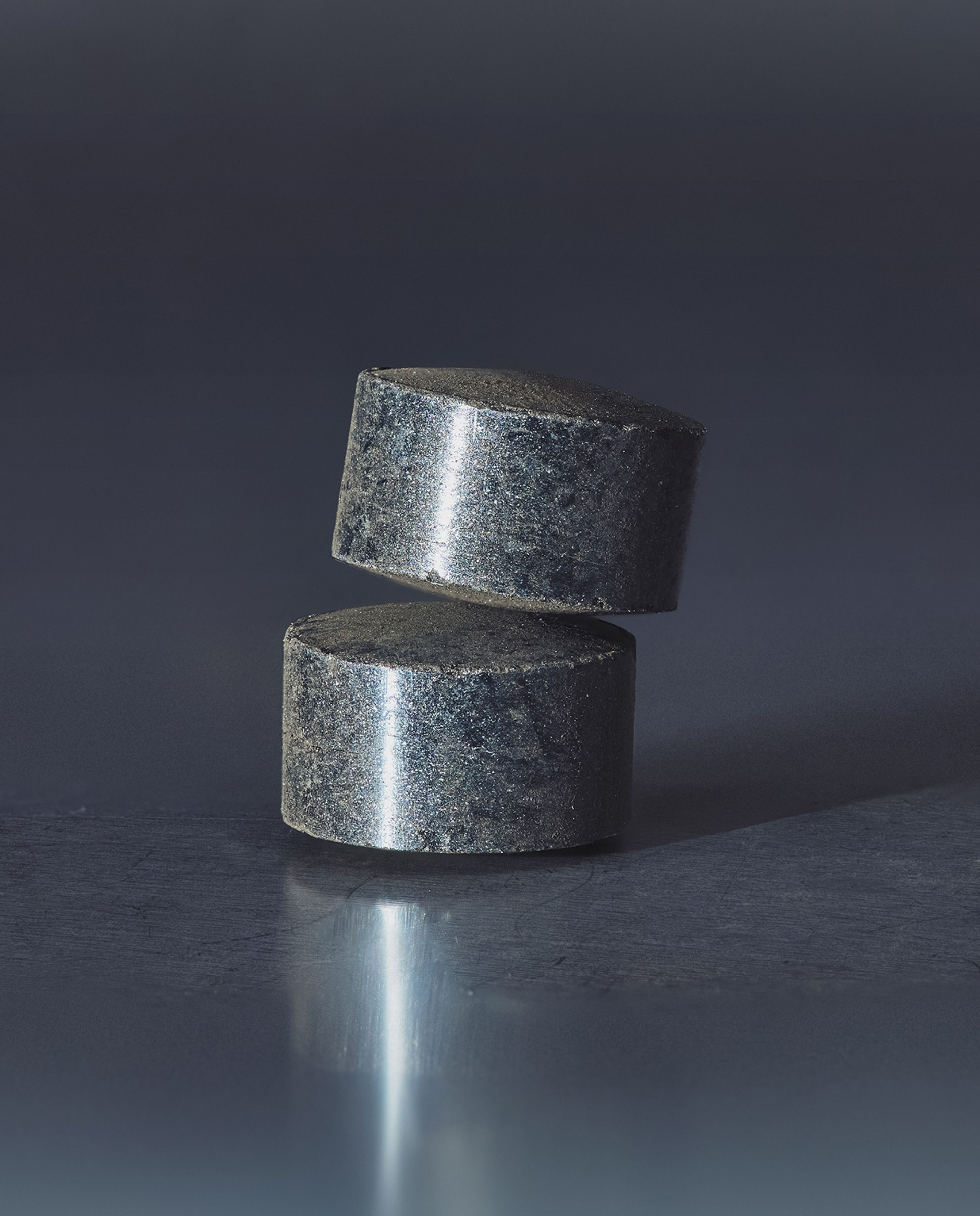 Two catalyst pellets stacked on top of one another on a table