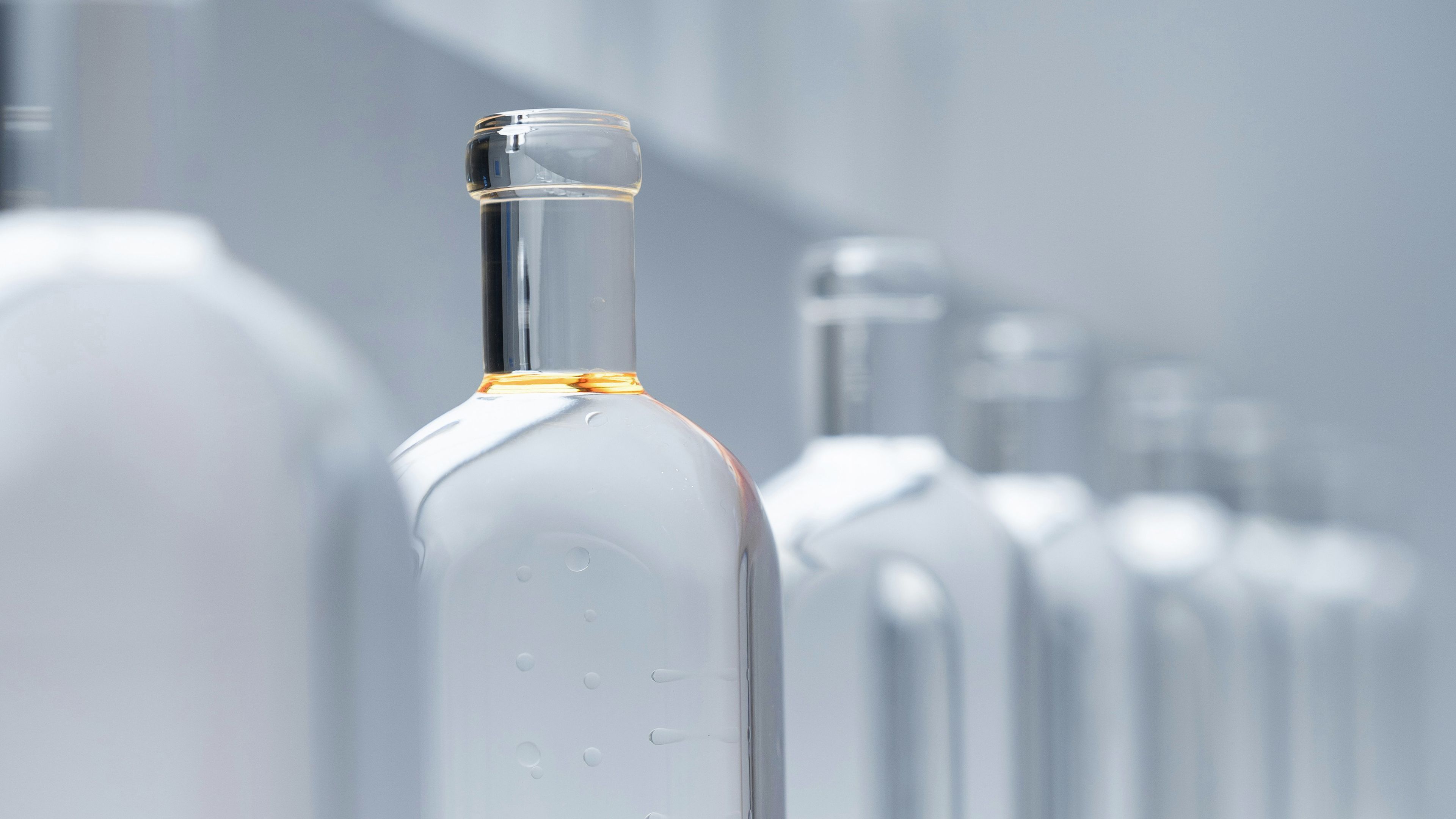 A row of clear bottles filled with Ethanol