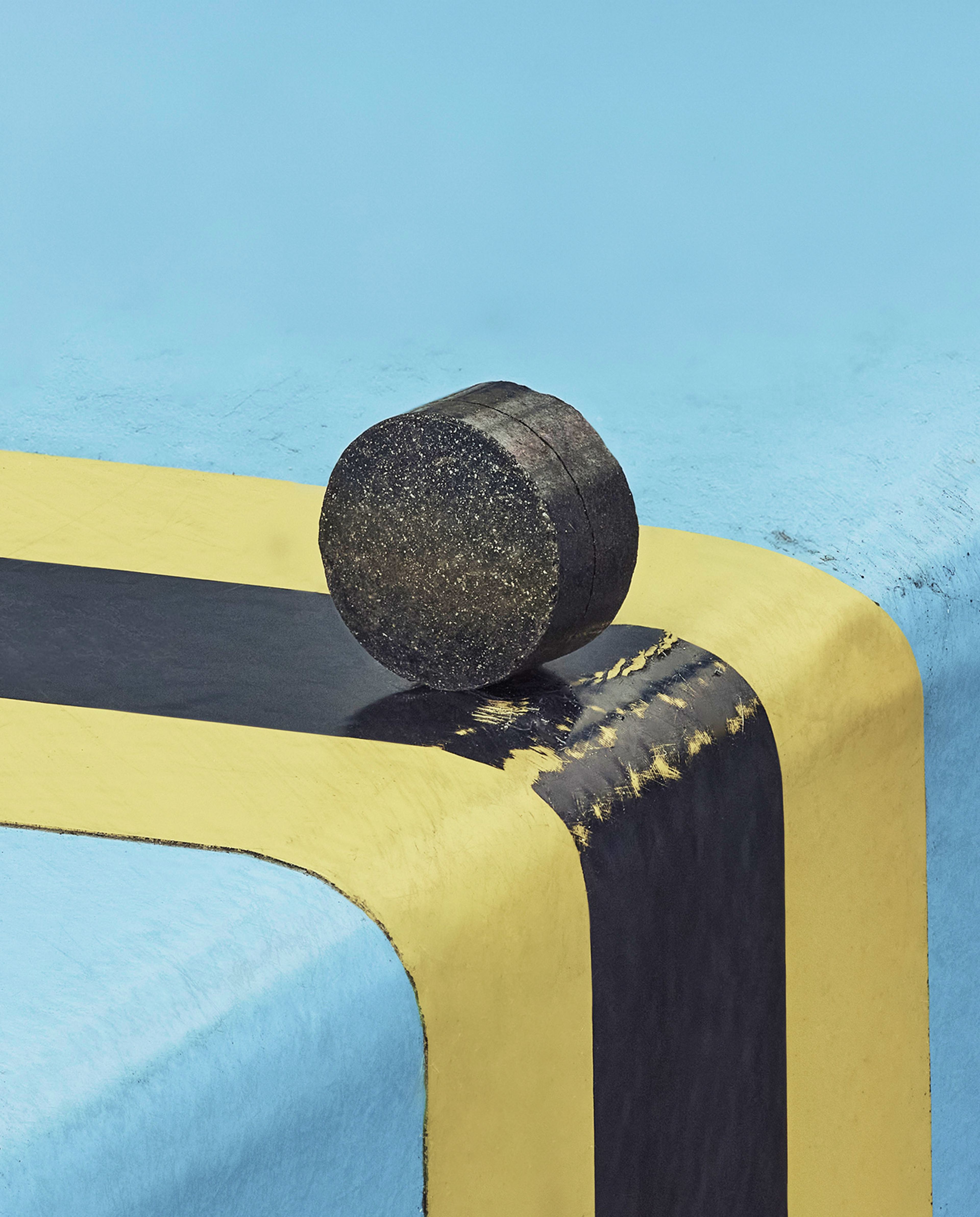 Catalyst pellet standing up on a blue table with a yellow stripe across it