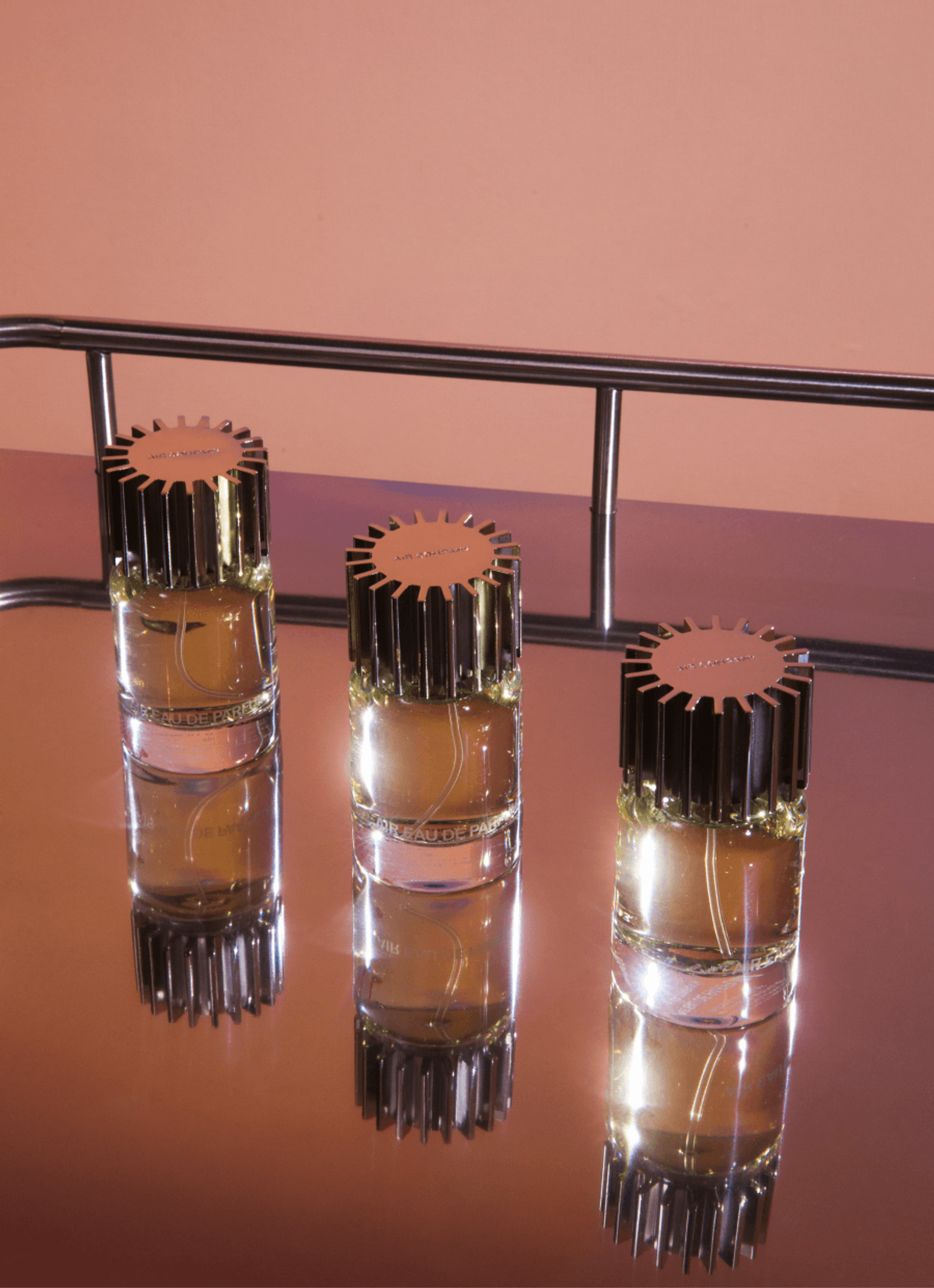 three glass fragrance bottles in a diagonal line
